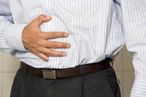 Man holding stomach due to constipation.