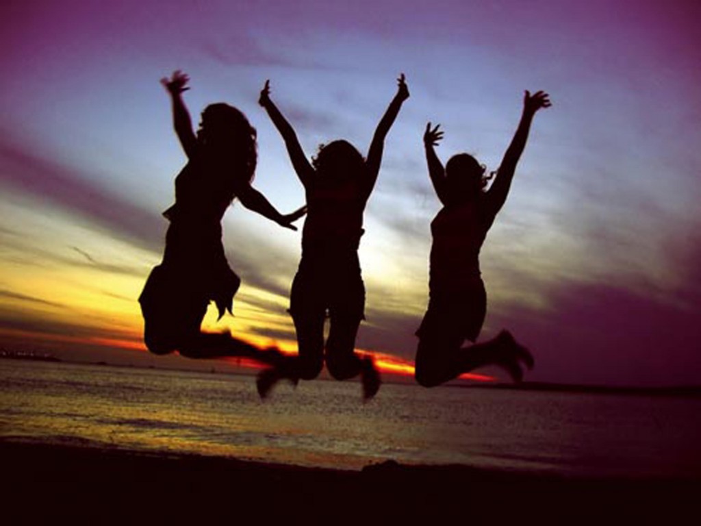 Happy Women Jumping in Sunset