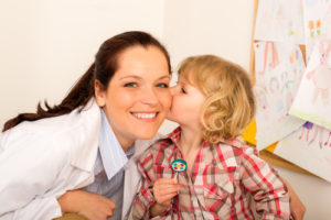 Child giving appreciative kiss to his health care worker.