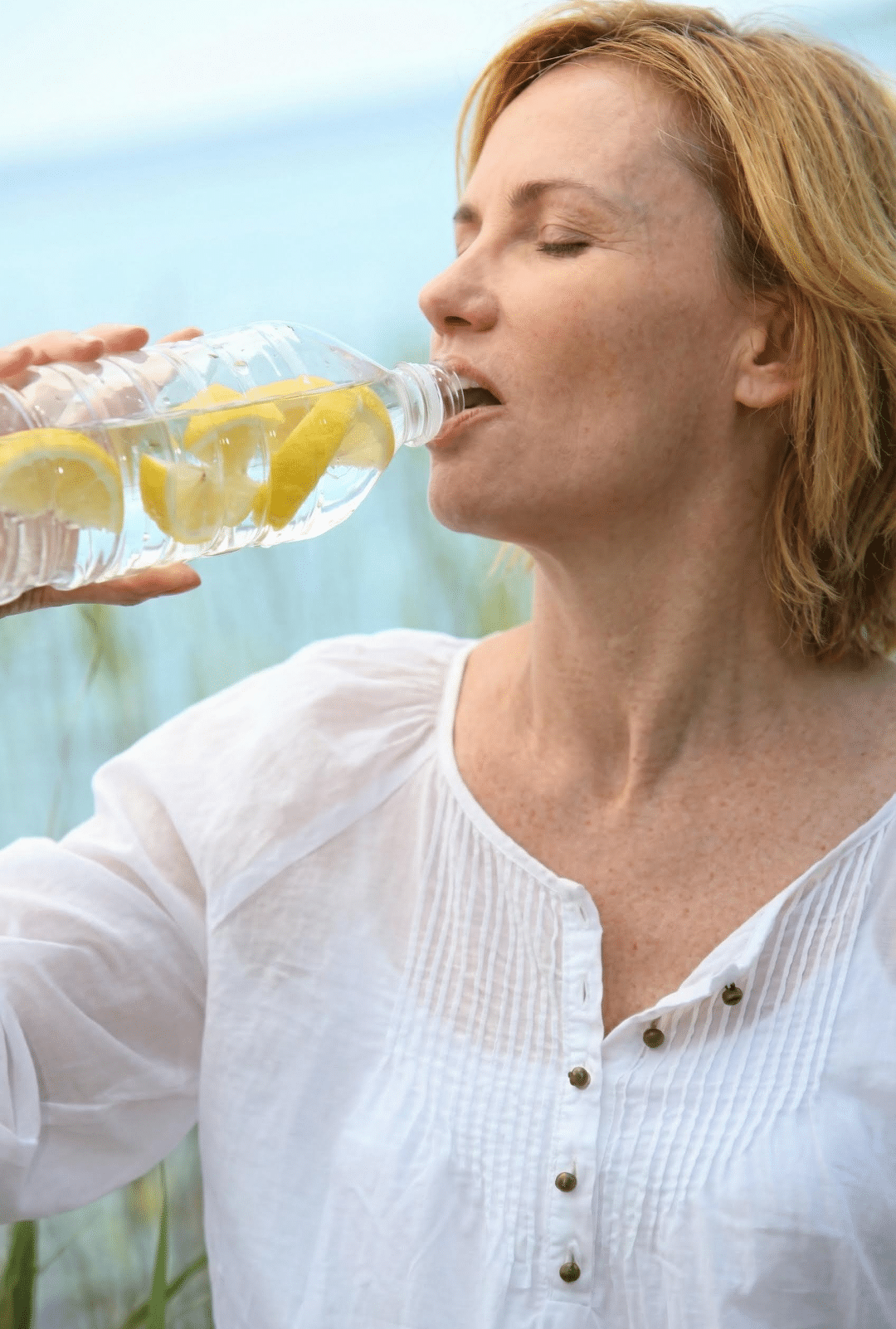 woman drinking water with lemons for her water flushes
