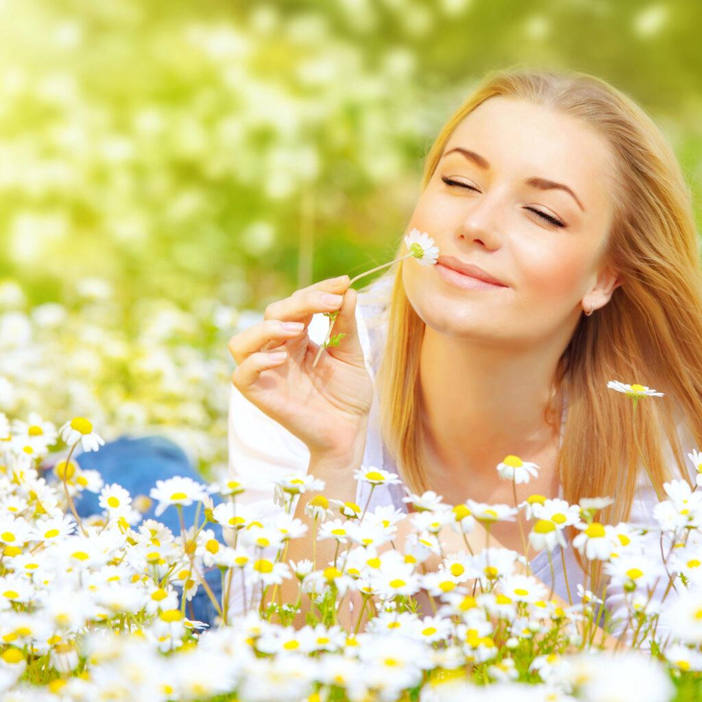 Woman enjoying the smell of daisies.